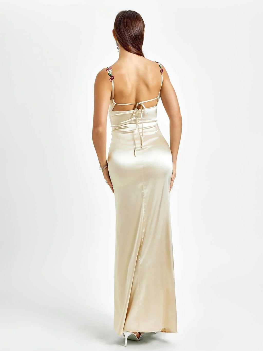 Robe longue ajustée sans manches en tissu léger, ornée de fleurs délicates pour une soirée élégante.