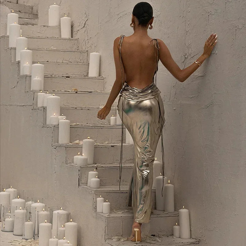 Robe longue argentée métallisée, sans manches, avec une coupe asymétrique et un tissu brillant, idéale pour les soirées.