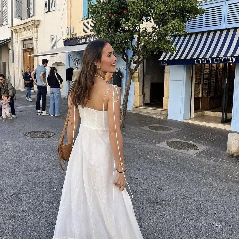 Robe longue blanche à bretelles fines, en coton léger, avec un buste froncé pour un look décontracté d'été.