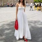 Robe longue blanche à bretelles fines, en coton léger, avec buste froncé et coupe estivale idéale pour des journées chaudes.