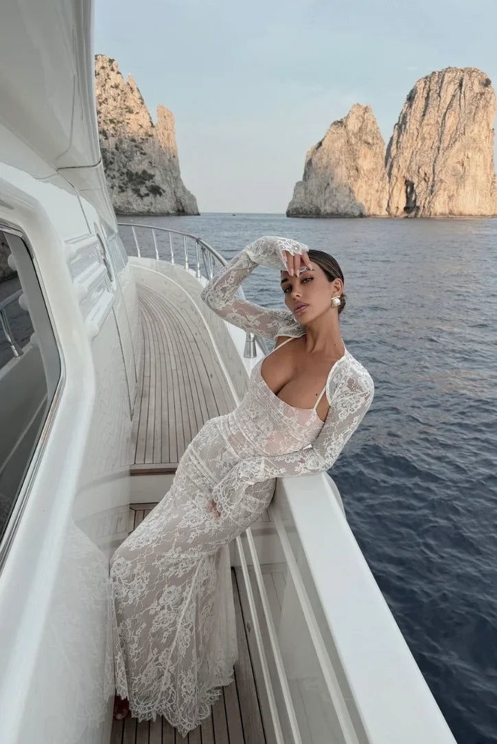 Robe longue blanche en dentelle, manches longues, avec une coupe élégante parfaite pour les mariages ou les cocktails.