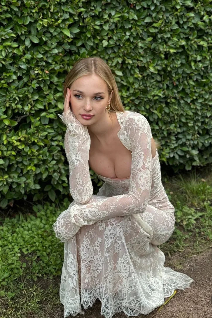 Robe longue blanche en dentelle, manches longues, idéale pour mariage ou cocktail, avec une coupe élégante et détaillée.