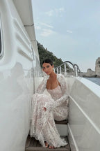 Robe longue blanche en dentelle, manches longues, avec une silhouette élégante et des détails délicats pour occasions…