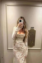 Robe longue blanche en dentelle, manches longues, idéale pour mariage ou cocktail, avec une coupe fluide et élégante.