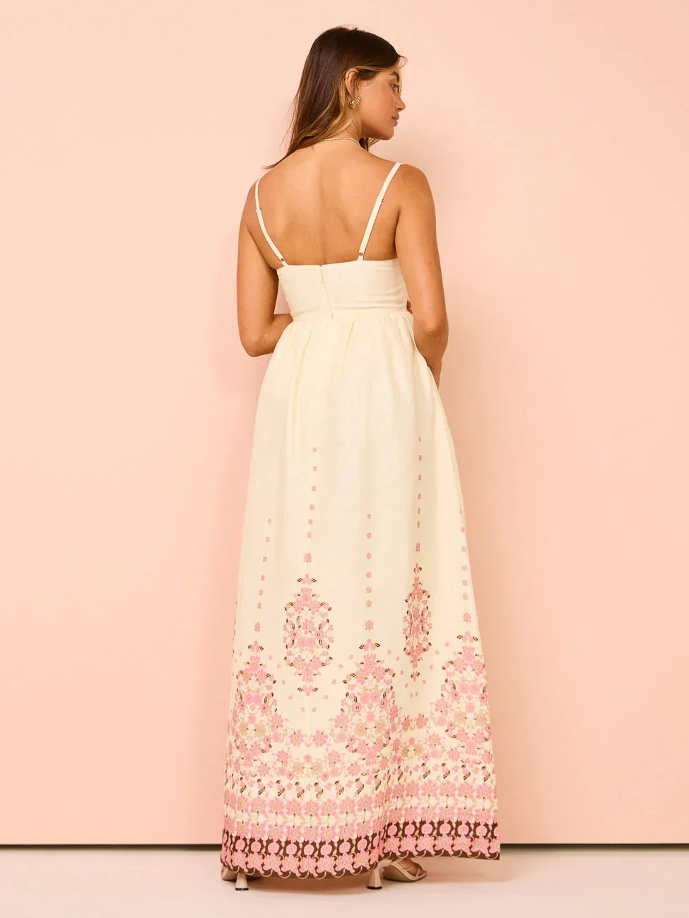 Robe longue blanche en tissu léger avec motifs floraux, ourlet détaillé et bretelles fines idéale pour l'été.