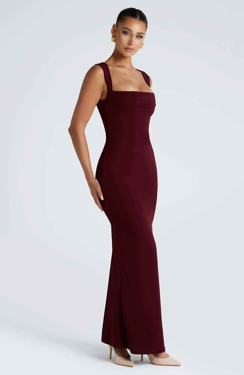Robe longue sans manches bordeaux en tissu fluide, décolleté en V et taille marquée pour une silhouette élégante.