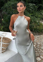 Robe longue grise en satin, col halter et dos nu, idéale pour une soirée élégante. Matériau soyeux et fluide.