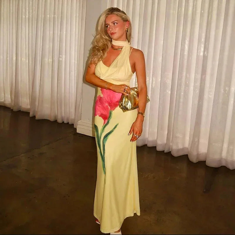 Robe longue jaune fleurie en tissu léger, col licou, coupe ajustée, idéale pour des journées d'été avec son imprimé floral.