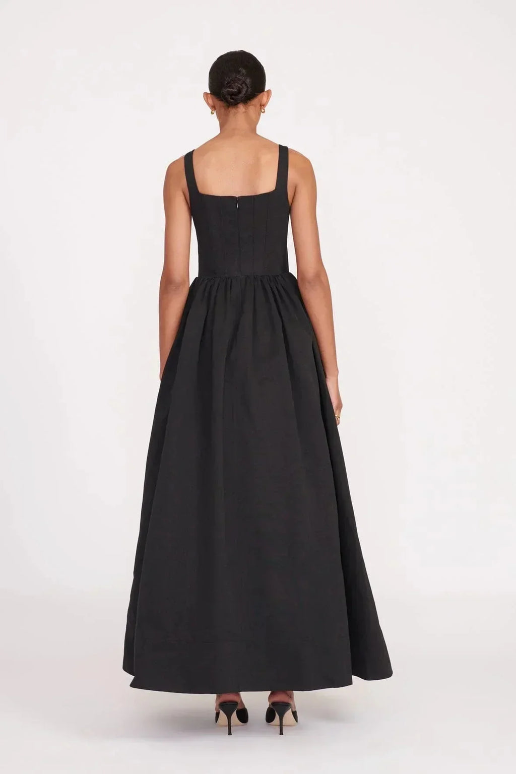 Robe longue noire sans manches avec col carré, en tissu doux et fluide, parfaite pour les soirées élégantes.