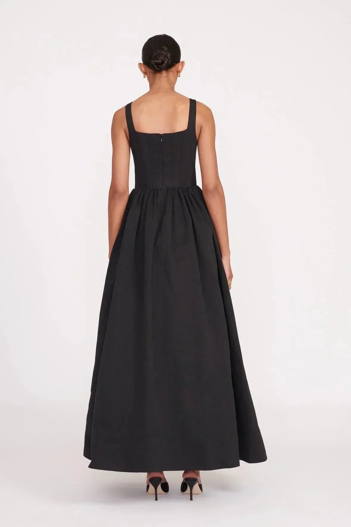 Robe longue noire sans manches avec col carré, en tissu doux et fluide, parfaite pour les soirées élégantes.