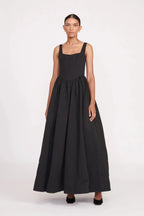 Robe longue noire sans manches avec col carré, en tissu fluide, parfaite pour une soirée élégante.