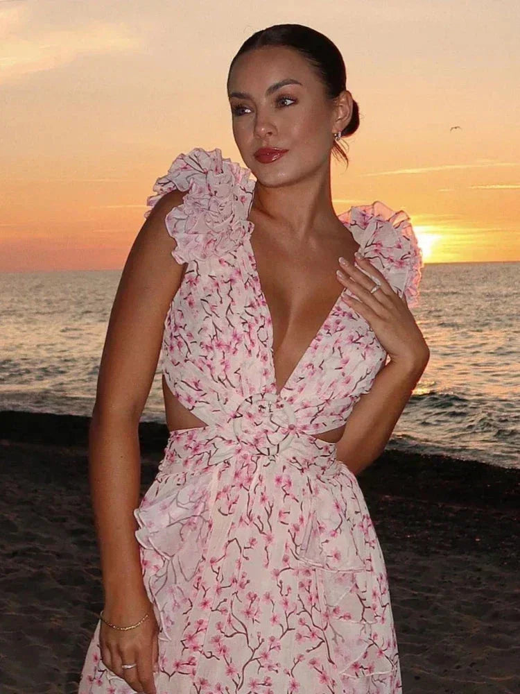 Robe longue rose portefeuille en tissu léger, décolleté en V, volants élégants et motifs floraux pour soirées d'été.