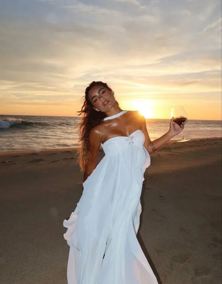 Robe longue sans bretelles en tissu léger, ornée de volants élégants et d’un embellissement floral délicat.