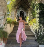 Robe longue sans bretelles, en tissu léger, avec volants délicats et embellissement floral coloré. Parfaite pour les…