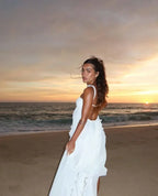 Robe longue sans bretelles, en tissu léger, avec volants délicats et embellissements floraux sur le décolleté.