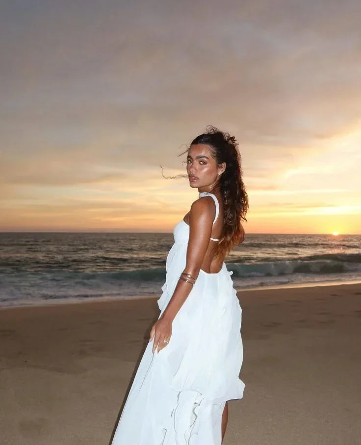 Robe longue sans bretelles, en tissu léger, avec volants délicats et embellissements floraux sur le décolleté.