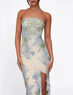 Robe longue sans bretelles en tissu léger, avec motif floral vibrant et fente sur le côté pour plus de confort et de style.