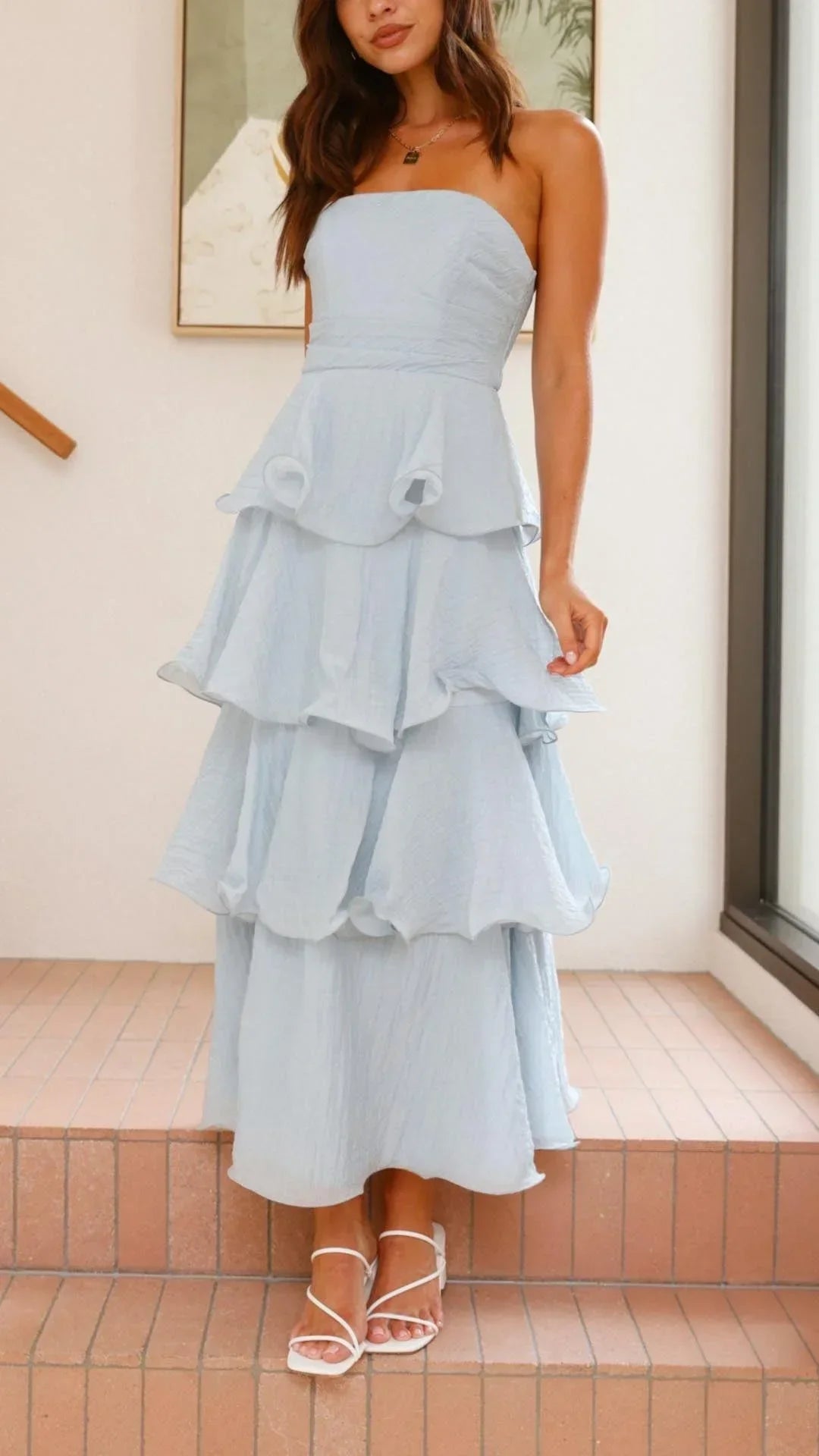 Robe longue sans bretelles en tissu léger, avec des volants en couches pour un look fluide et élégant lors des soirées.