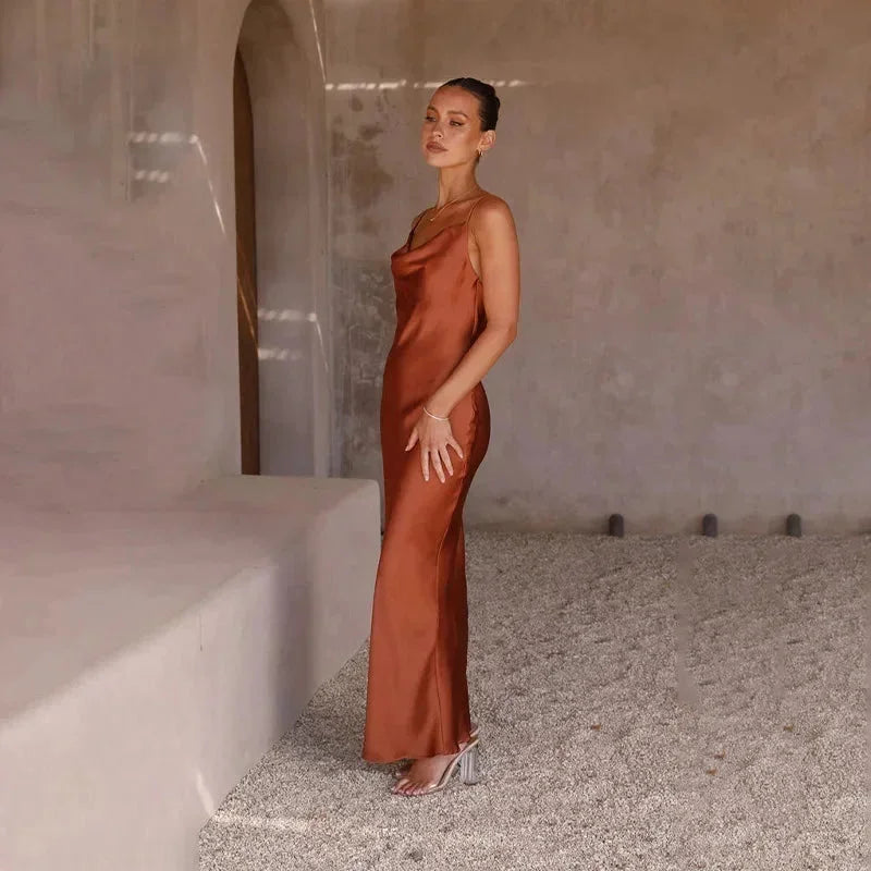 Robe longue sans manches en satin avec col bénitier, disponible en plusieurs couleurs, idéale pour les occasions spéciales.