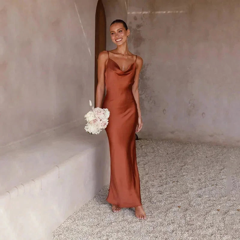 Robe longue sans manches en satin, col bénitier élégant, disponible en plusieurs couleurs. Parfaite pour les occasions…