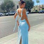 Robe longue en satin avec col bénitier, dos ouvert et liens latéraux, offrant une silhouette élégante et fluide.