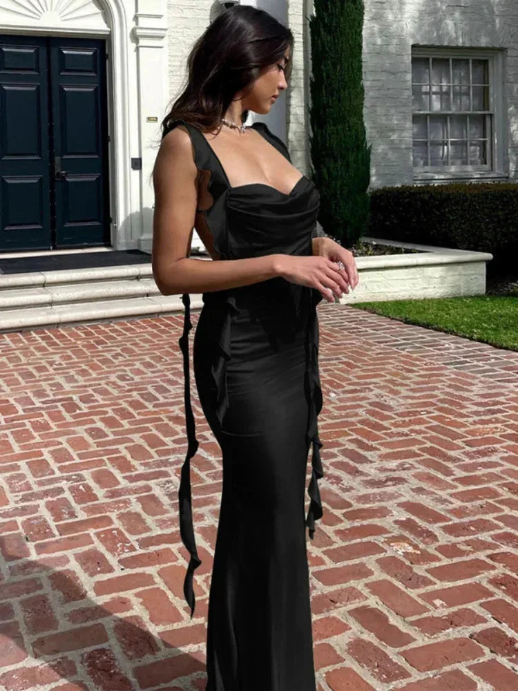 Robe longue satinée avec col bénitier, dos ouvert et liens latéraux, parfaite pour une allure élégante.