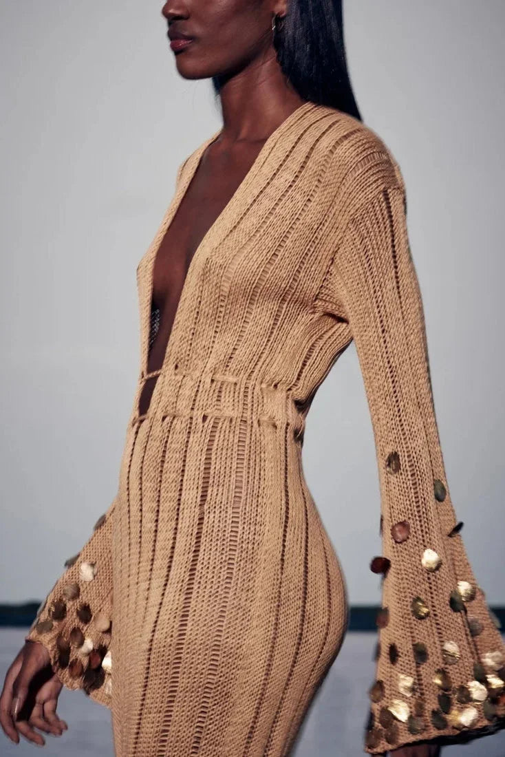 Robe longue transparente dorée à sequins, manches longues, décolleté plongeant, idéale pour les soirées élégantes.