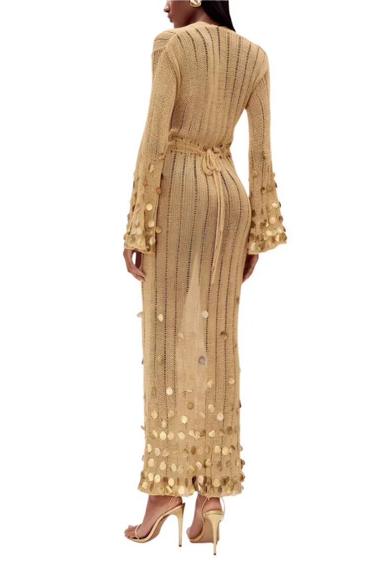 Robe longue transparente dorée à sequins, manches longues, décolleté plongeant, idéale pour les soirées élégantes.