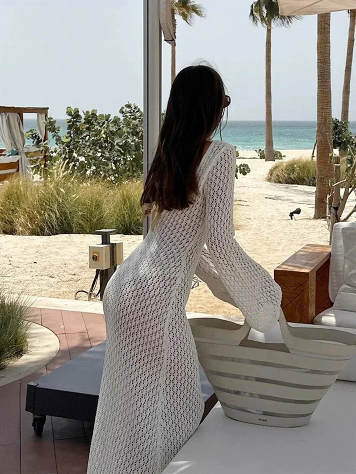 Robe longue tricotée en maille douce, avec un lien décolleté et des manches longues pour un confort élégant.