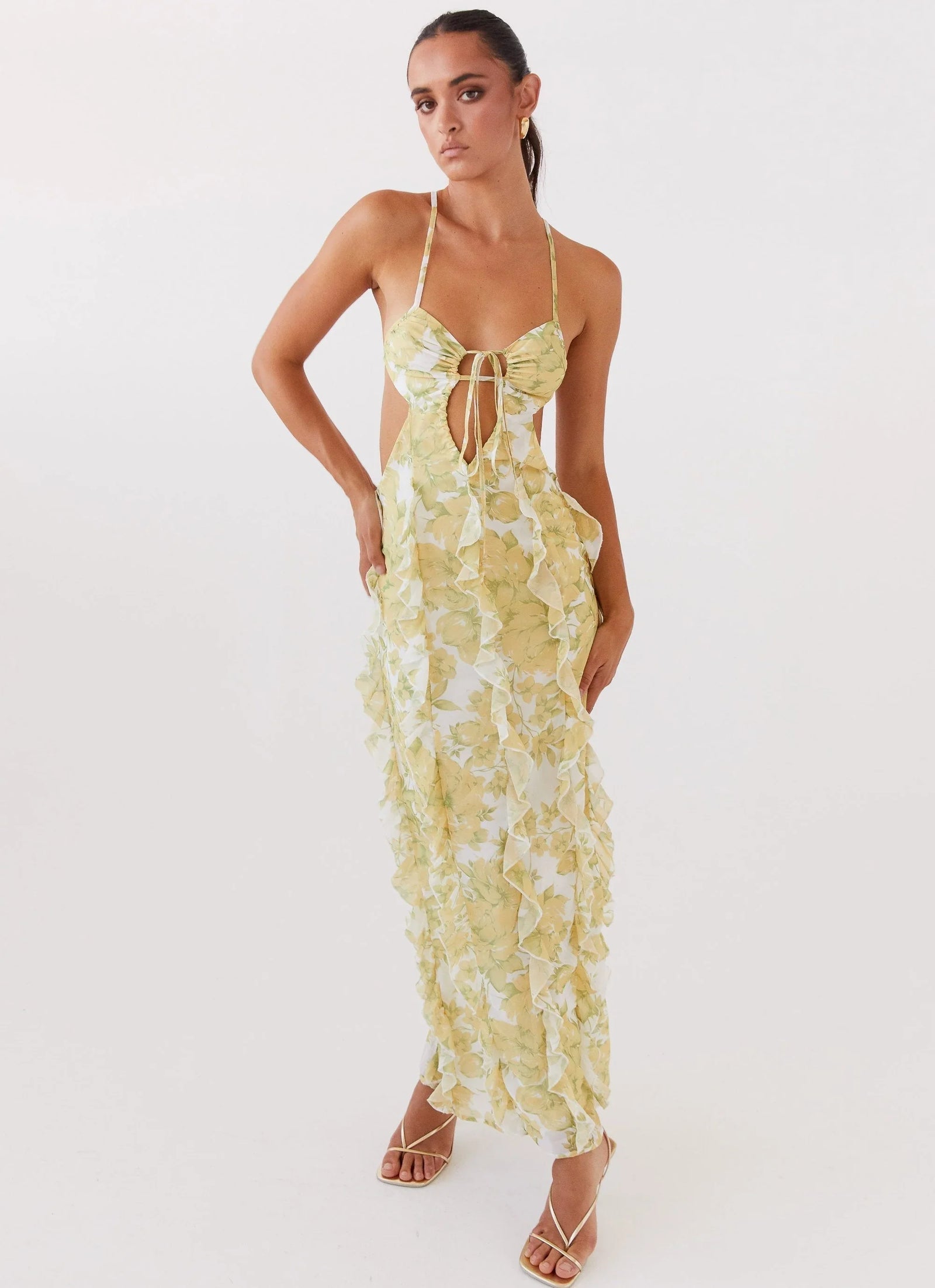 Robe longue à volants en coton, motif floral jaune, avec une coupe fluide et des manches courtes. Parfaite pour l'été.