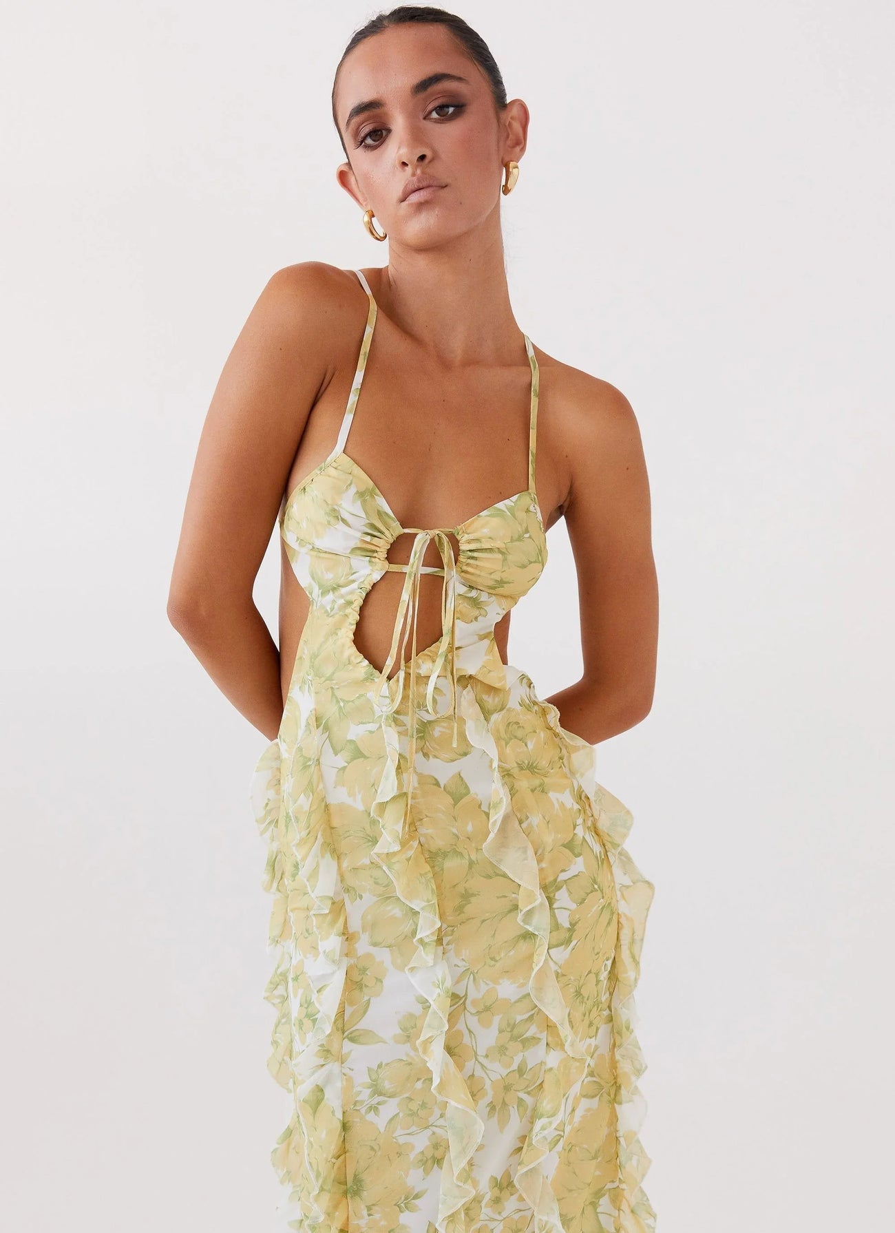 Robe longue à volants en coton, présentant un motif floral jaune vibrant et des détails délicats sur les manches.