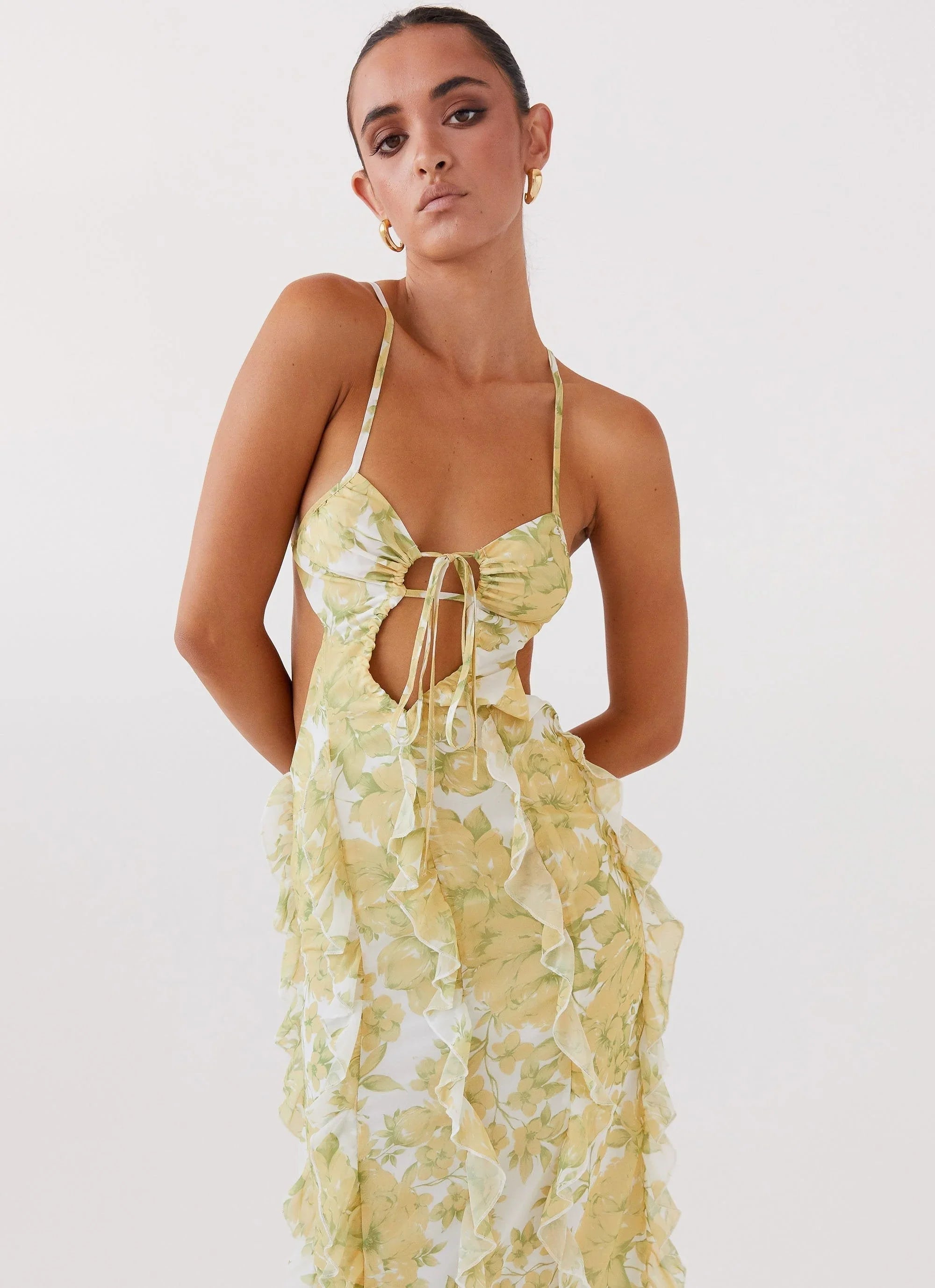 Robe longue à volants en coton, présentant un motif floral jaune vibrant et des détails délicats sur les manches.