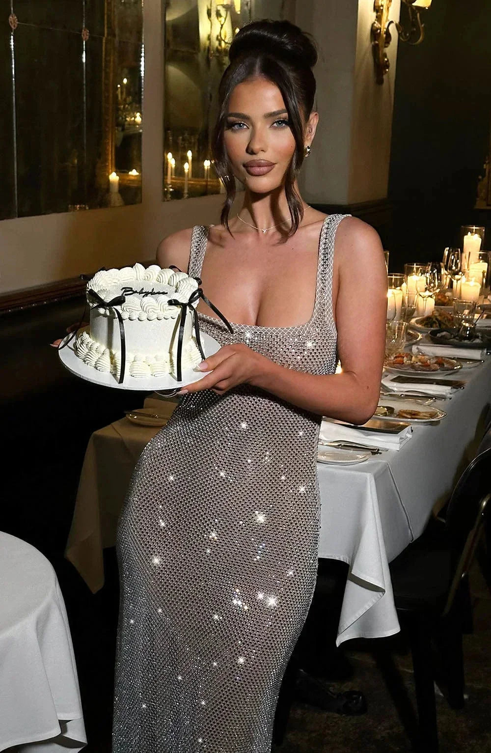 "Robe longue argentée en maille ajustée, sans manches, parfaite pour les soirées élégantes avec un design moderne."