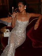 Robe longue argentée en tissu scintillant, sequins brillants, décolleté carré, bretelles fines, idéale pour soirées.