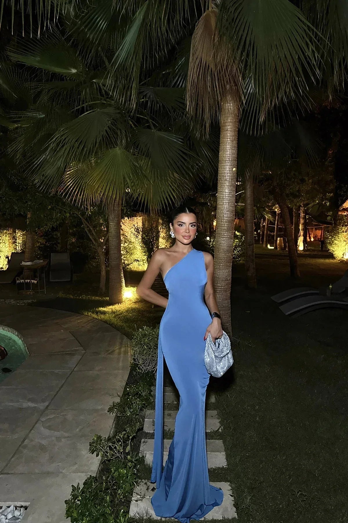 Robe longue bleue asymétrique avec fente latérale, sans manches, en tissu léger et fluide, idéale pour les soirées.