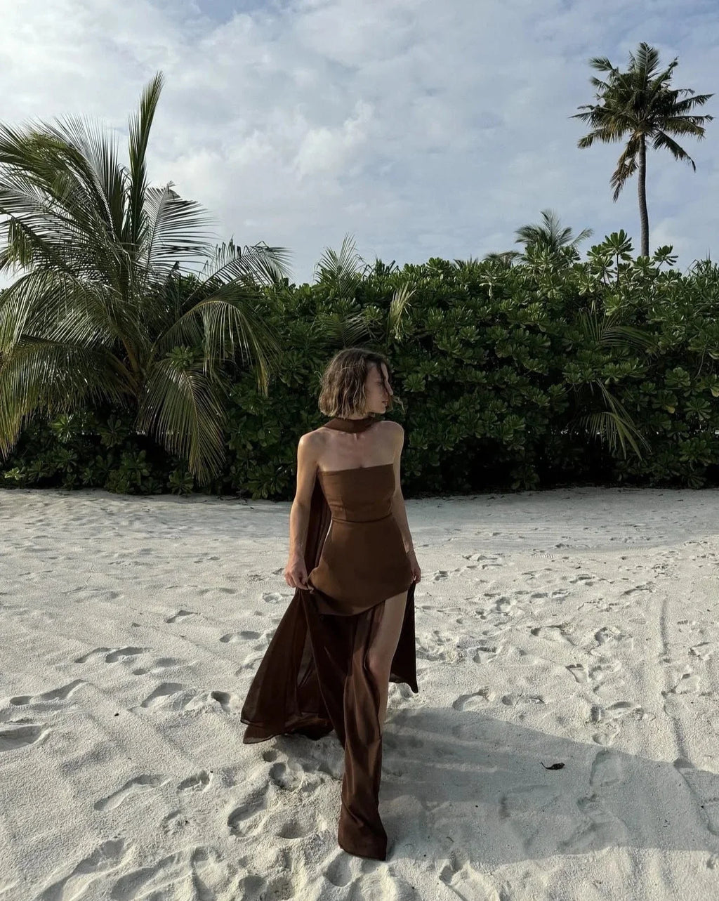 Robe longue asymétrique sans manches avec un col bustier et des couches fluides, parfaite pour les occasions spéciales.