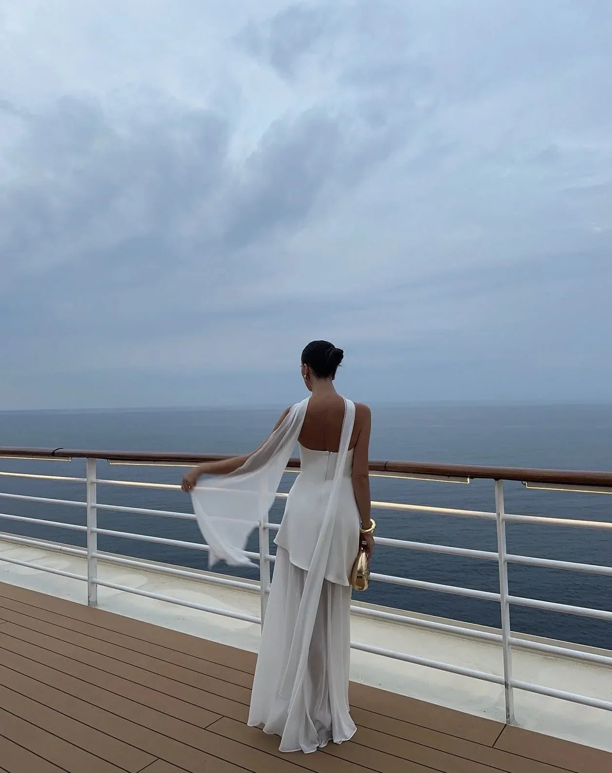 Robe longue asymétrique sans manches avec col bustier, en tissu léger à plusieurs étages pour une silhouette élégante.