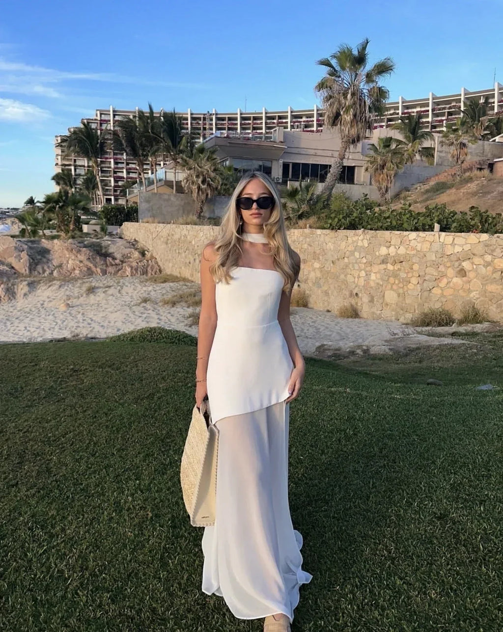 Robe longue asymétrique sans manches, en tissu léger, avec col bustier et étages fluides pour une silhouette élégante.