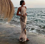 Robe longue beige avec imprimé coquillage, coupe ajustée sans manches et col haut, idéale pour des soirées élégantes.