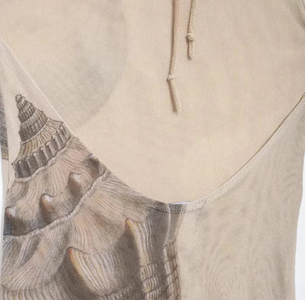 Robe longue beige avec imprimé coquillage, coupe ajustée sans manches et col haut, idéale pour les soirées élégantes.