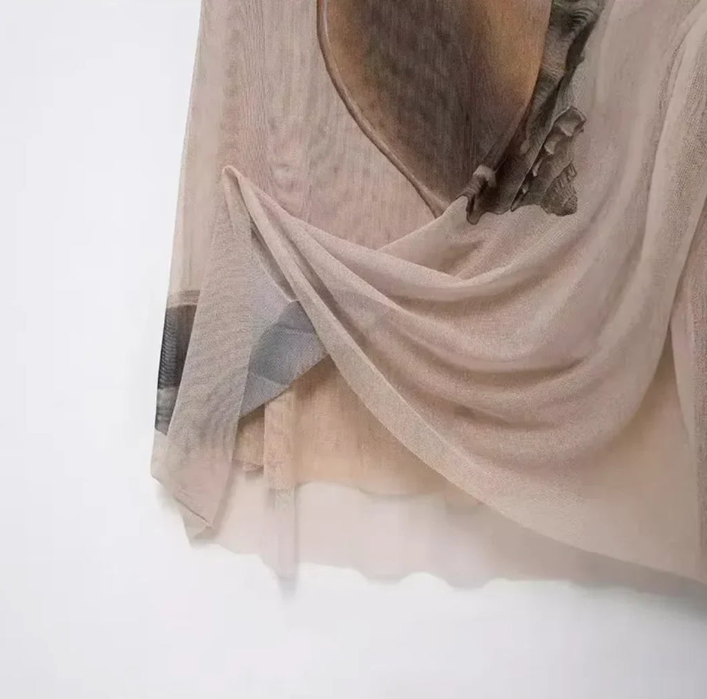 Robe longue beige sans manches avec imprimé coquillage, col haut et coupe ajustée pour des soirées élégantes.