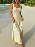 Robe longue beige sans manches pour femme, en tissu léger, avec motifs géométriques pour un look estival élégant.