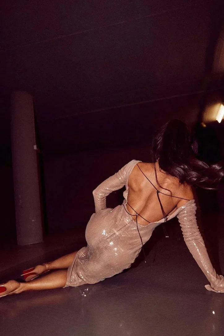 Robe longue beige en tissu léger, sequins brillants, manches longues et col en V profond, idéale pour les soirées élégantes.