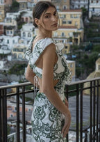 Robe longue blanche et verte à volants, en tissu léger, avec un dos noué, idéale pour l'été et les occasions décontractées.