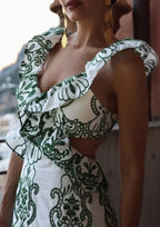 Robe longue blanche et verte à volants, en tissu léger, avec un dos noué et un design fluide parfait pour l'été.