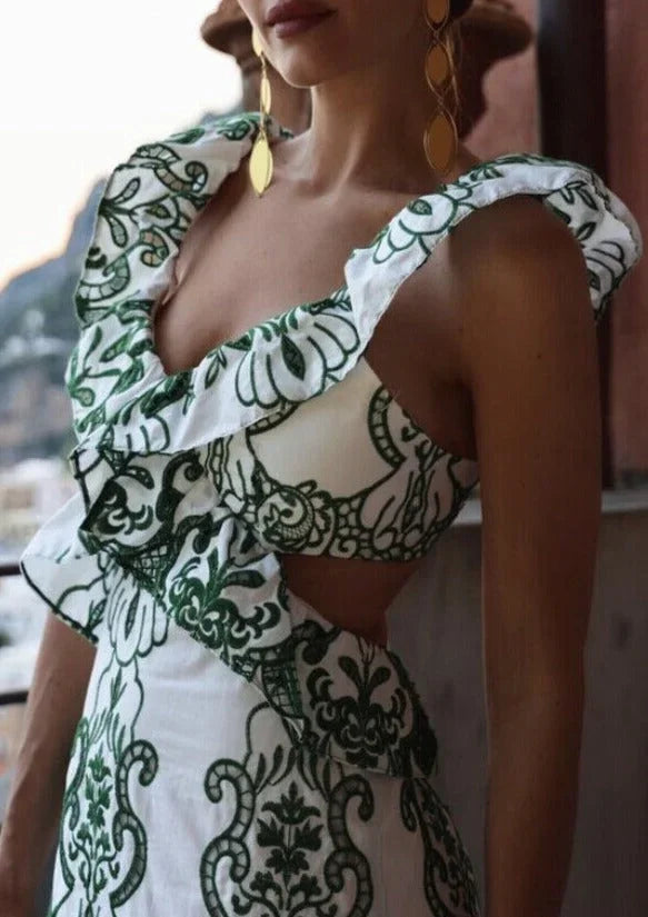 Robe longue blanche et verte à volants, en tissu léger, avec un dos noué et un design fluide parfait pour l'été.