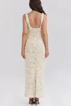 Robe longue blanche à fleurs, dos nu, bretelles plongeantes, tissu léger parfait pour une soirée d'été.