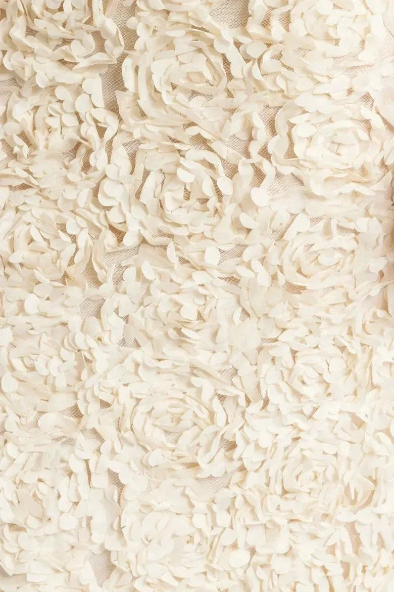 Alt text: Robe longue blanche en coton, motif floral, dos nu et bretelles plongeantes, parfaite pour les soirées d'été.