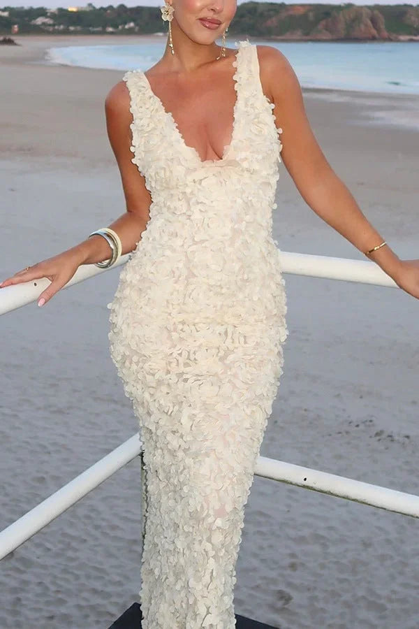 Robe longue blanche à fleurs, dos nu, bretelles plongeantes, idéale pour les soirées d'été, en tissu léger et fluide.