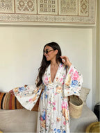 Robe longue bohème fleurie en tissu léger, manches longues, col en V et motifs floraux colorés pour une allure décontractée.